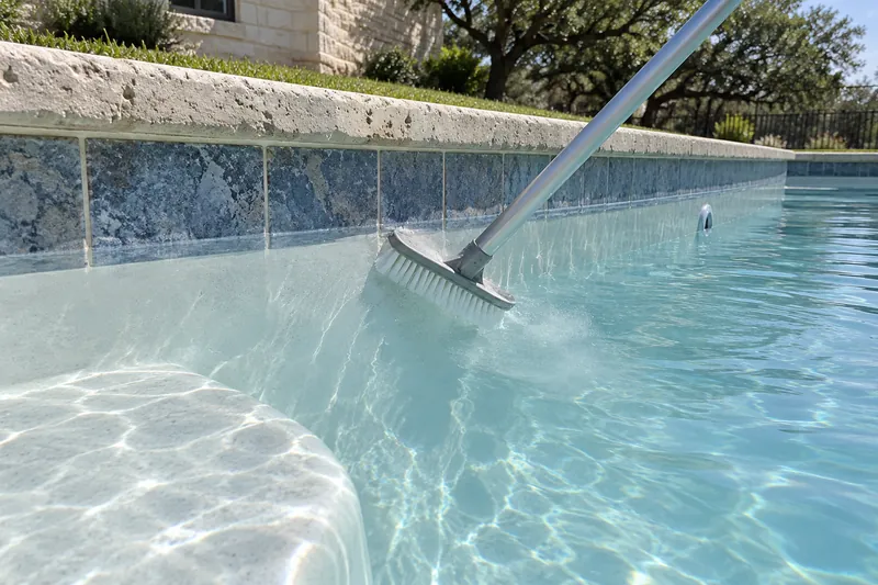 Brushing a newly filled plaster pool to lift plaster dust