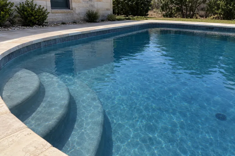 Gray colored pool plaster with natural mottling under clear water