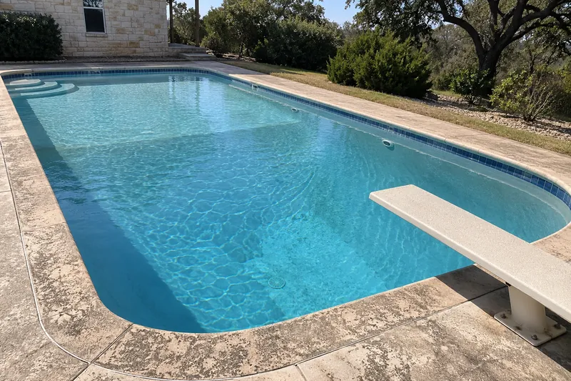 Older backyard pool with a diving board over a steep deep end