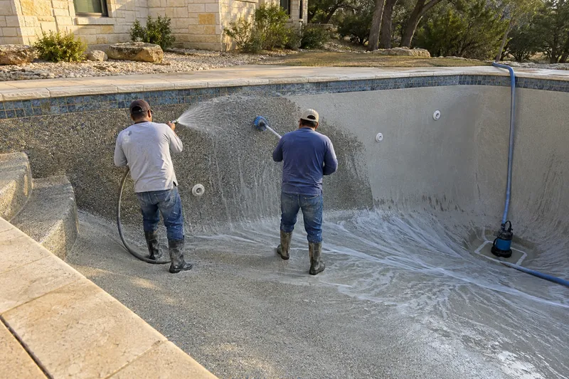 Cement paste being washed off a fresh pebble finish to expose the stones