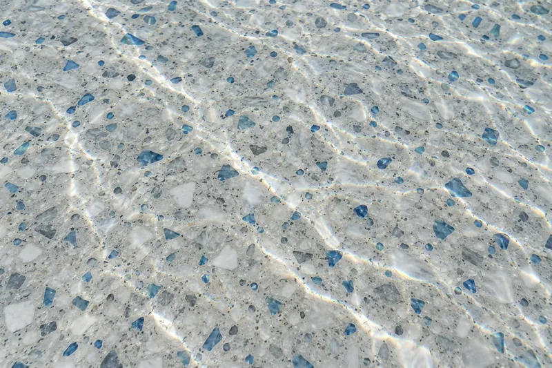 Polished marble and glass pool finish under clear water