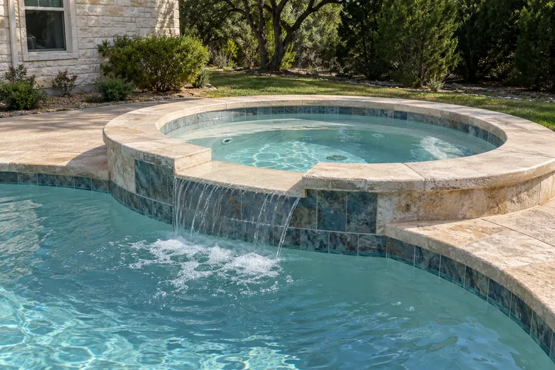 Resurfaced spa spilling into a backyard pool