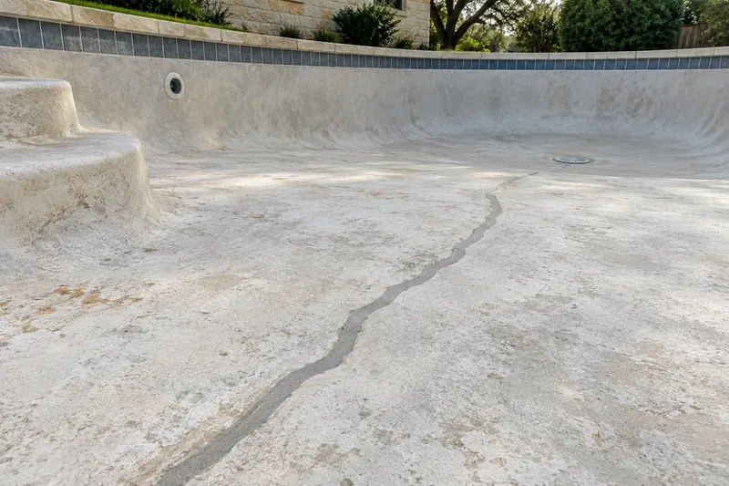 Routed and patched crack across a drained pool floor