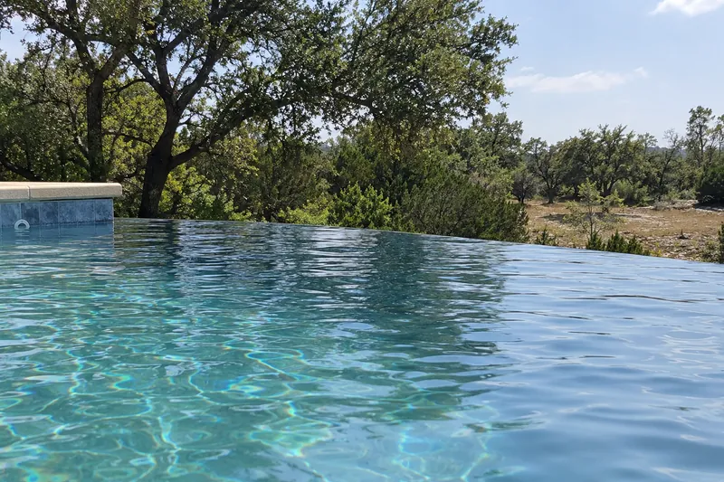 Water flowing smoothly over a tiled infinity edge